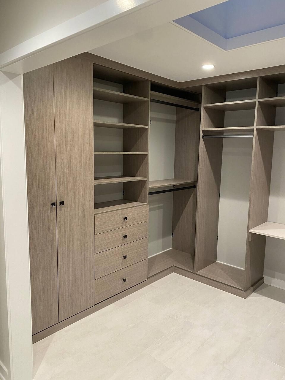 A walk in closet with lots of shelves and drawers