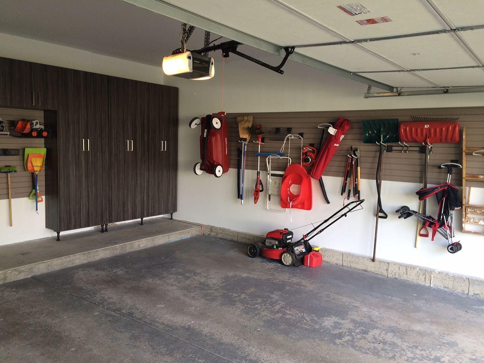 A garage filled with lots of tools and a lawn mower.