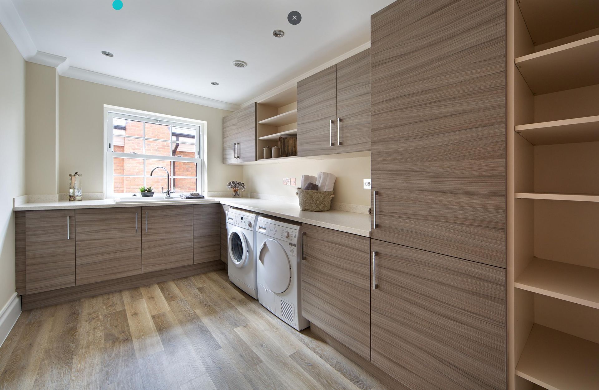 A laundry room with a washer and dryer and wooden cabinets.