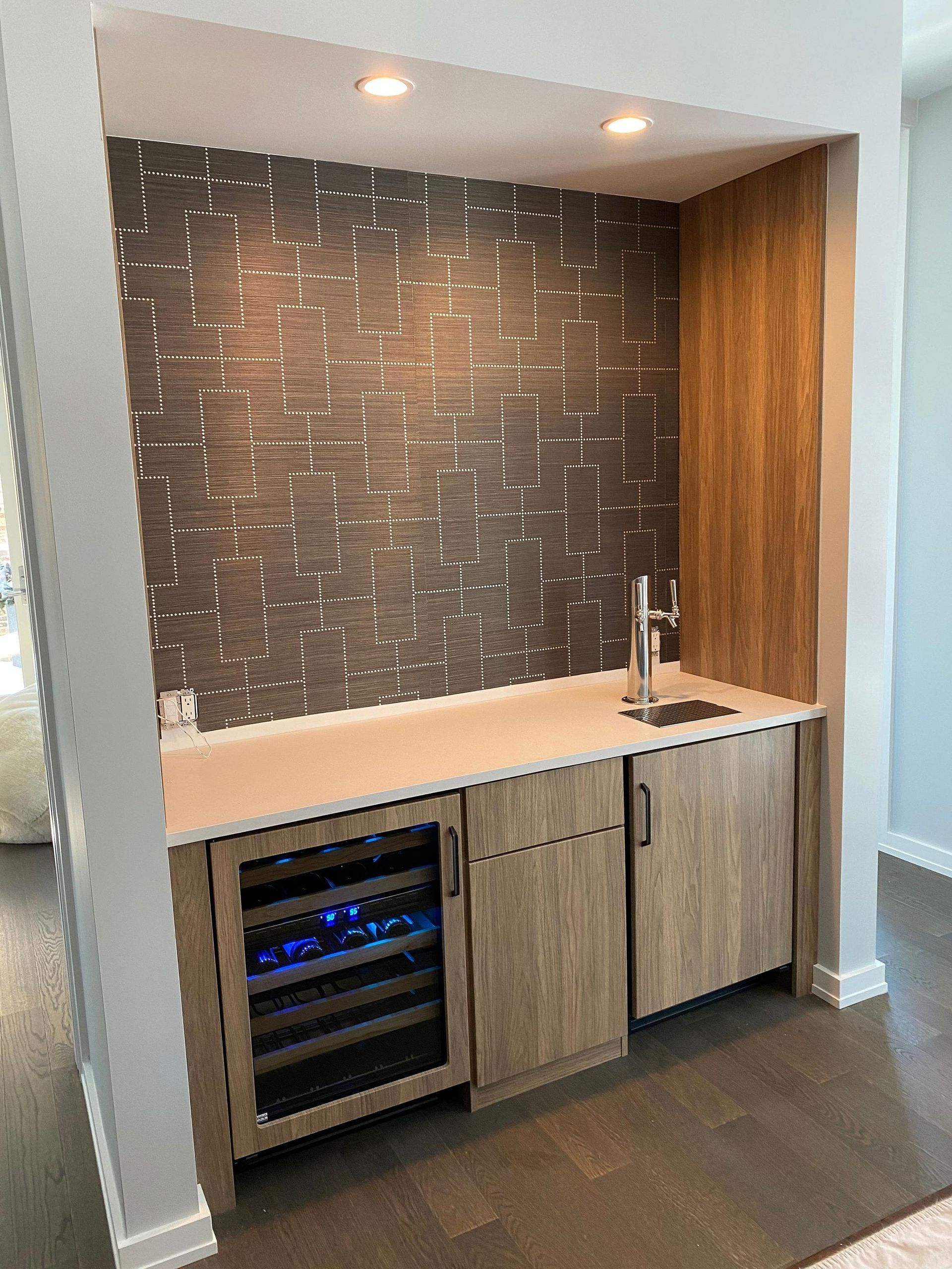 A kitchen with a sink , refrigerator , and wine cooler.