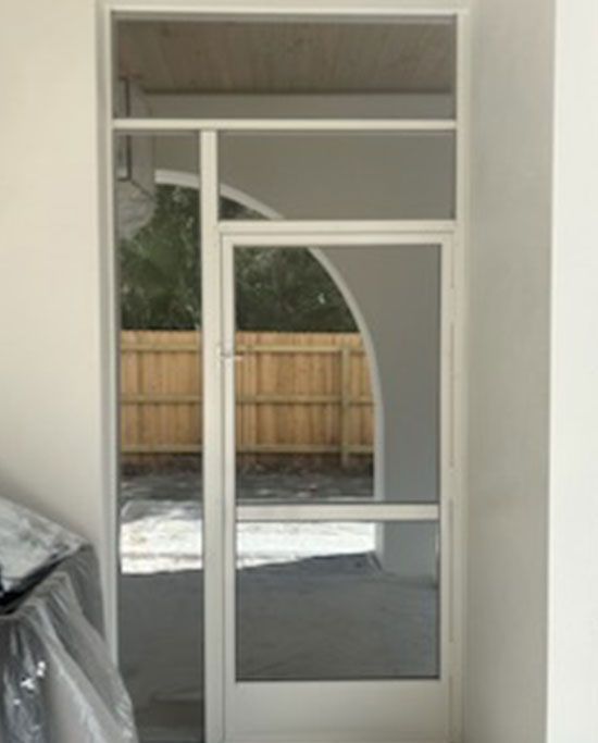 A white door with a wooden fence in the background.