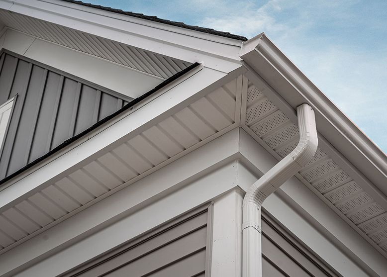 A close up of the corner of a house with a gutter.