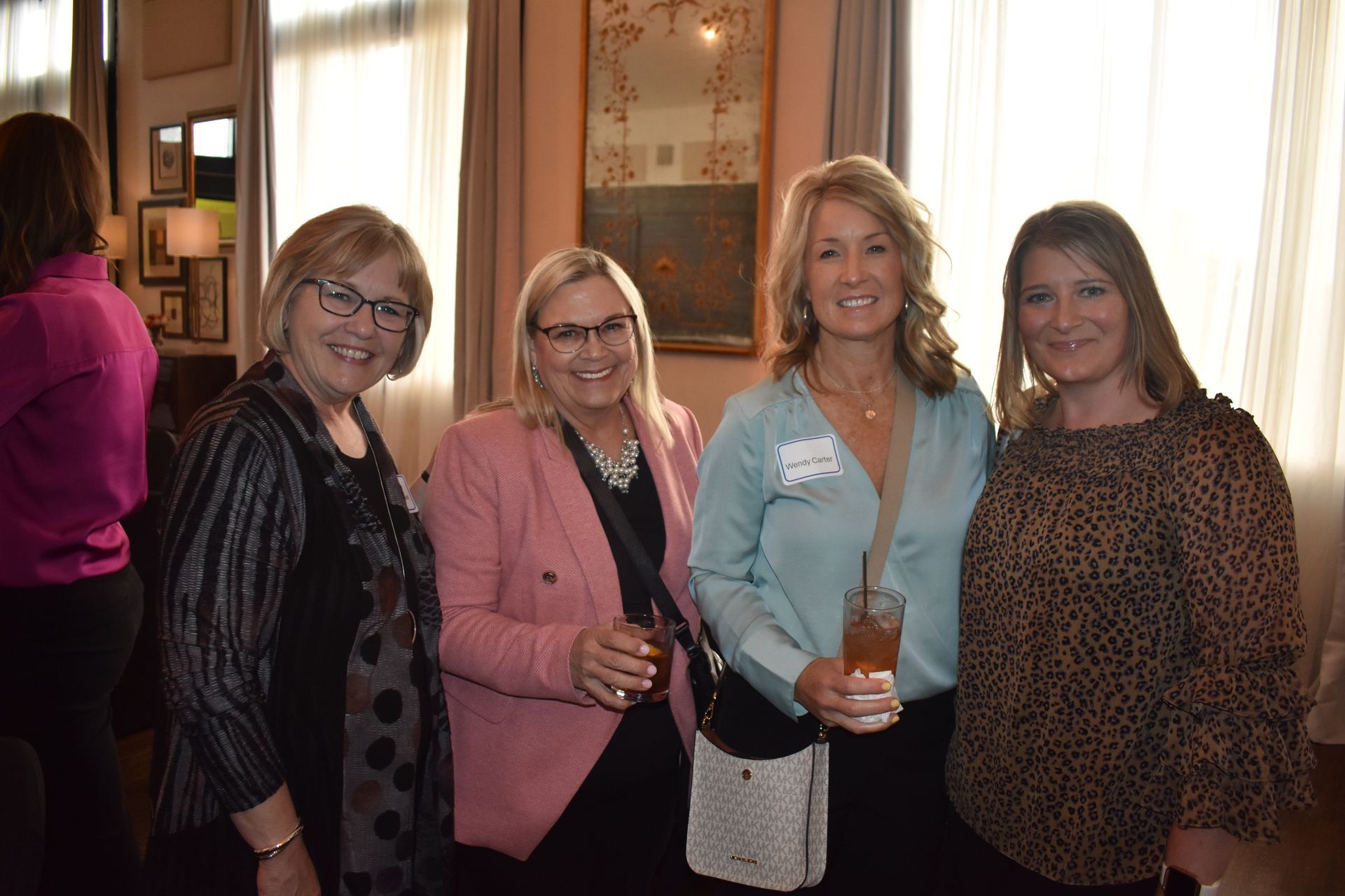 A group of people are sitting around a table looking at a laptop.