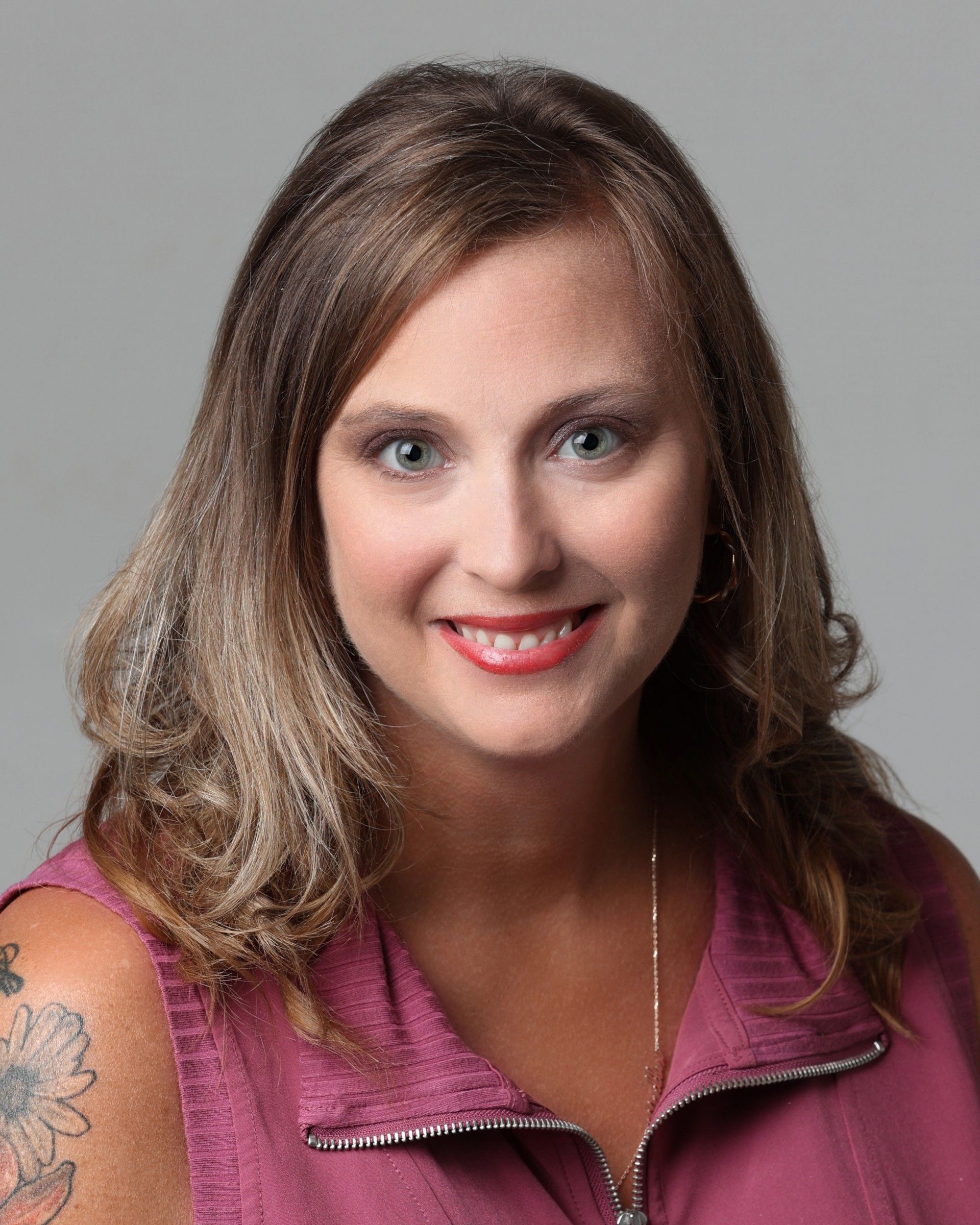 A man wearing glasses and a green shirt is smiling and looking up.