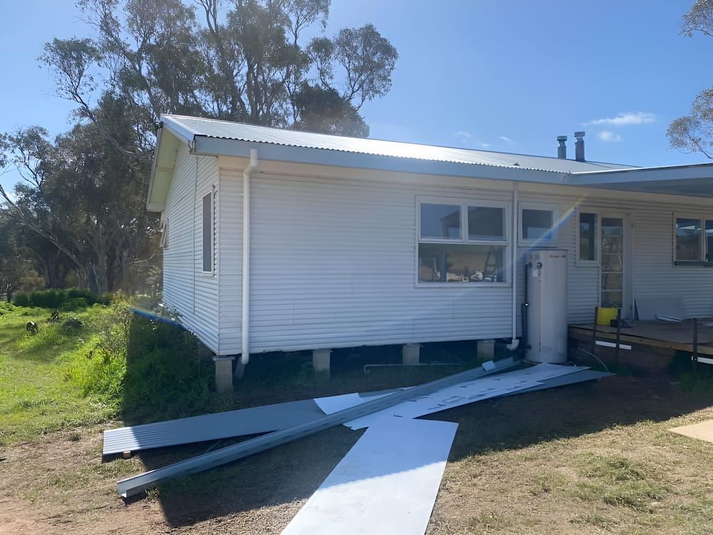 A White House Is Sitting In The Middle Of A Grassy Field — L & S Wirth Painting in Dubbo, NSW