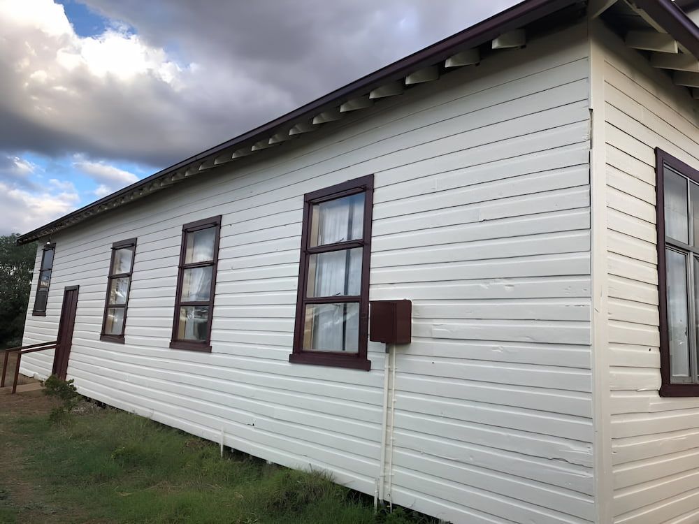 The Side Of A White House With Brown Trim And Windows — L & S Wirth Painting in Dubbo, NSW