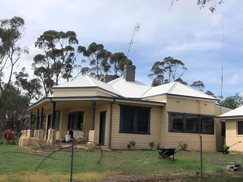 A House With A White Roof And A Wheelbarrow In Front Of It — L & S Wirth Painting in Dubbo, NSW
