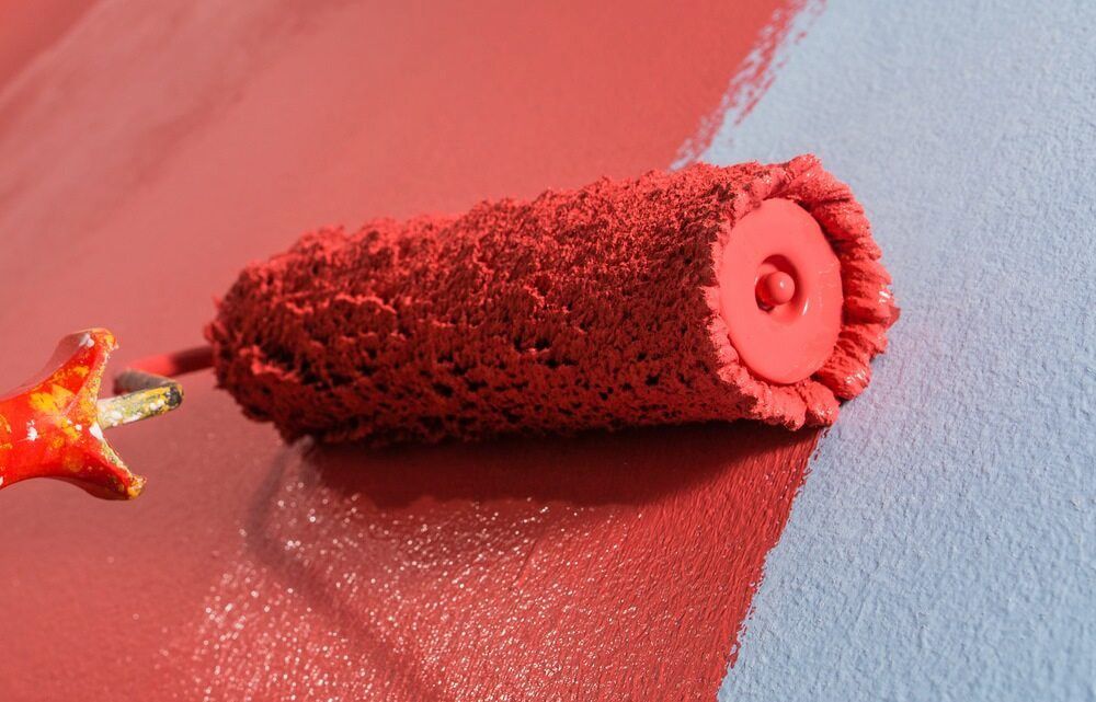 A Red Paint Roller Is Being Used To Paint A Blue Wall — L & S Wirth Painting in Parkes, NSW