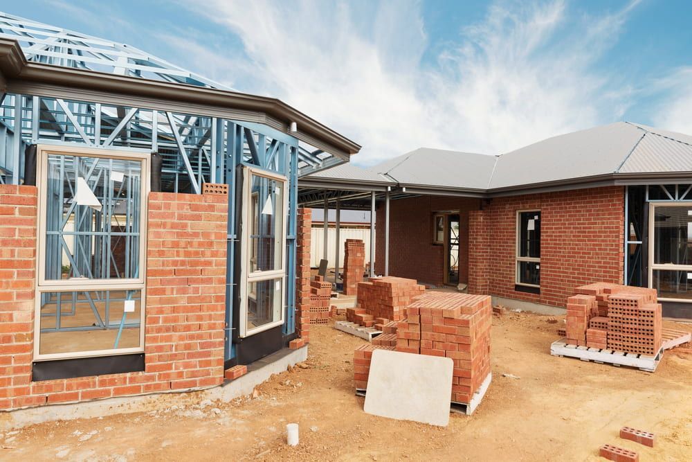 A House Is Being Built With Bricks And A Metal Frame — L & S Wirth Painting in Coonamble, NSW