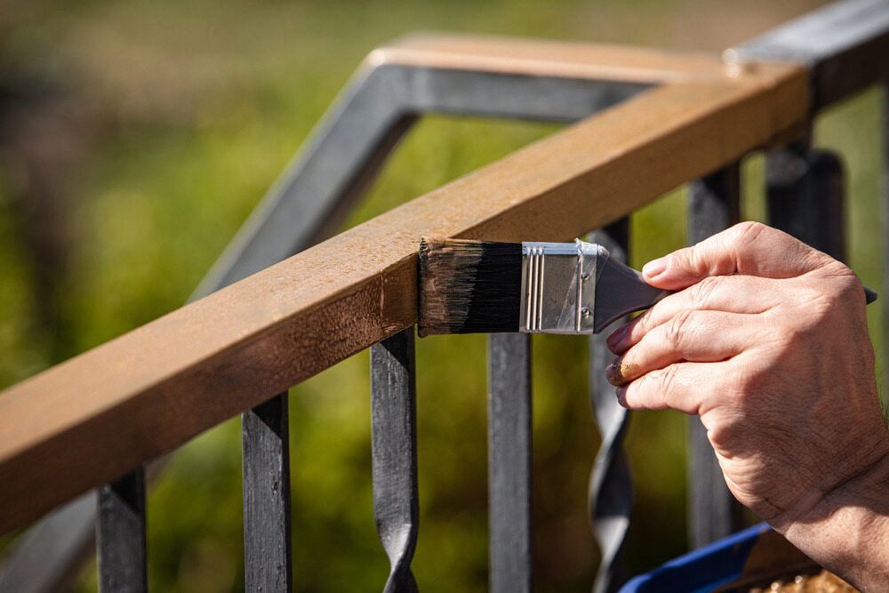 A Person Is Painting A Railing With A Brush — L & S Wirth Painting in Gilgandra, NSW