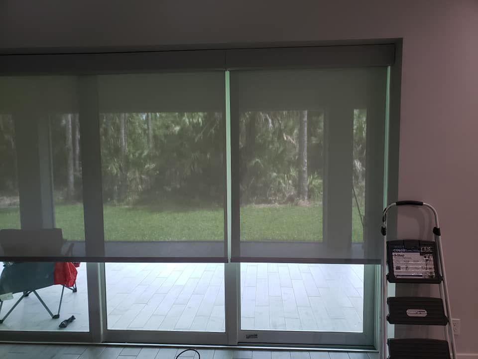 Vertical blinds covering large windows with a sliding glass door to a patio.