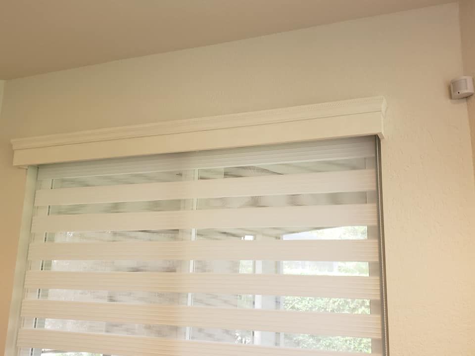 Patio with beige sun shades, pool view, glass table and chairs, light blue ceiling.