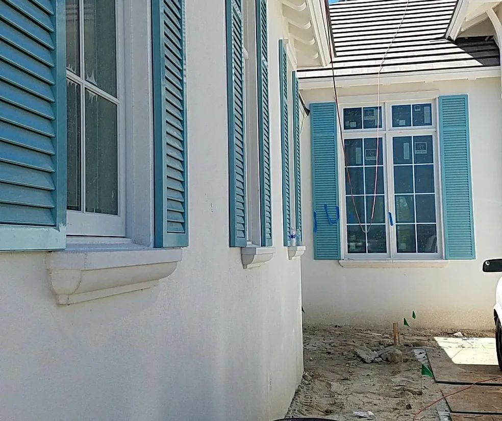 Dining area with white zebra blinds, table, chairs, and a pendant light fixture.