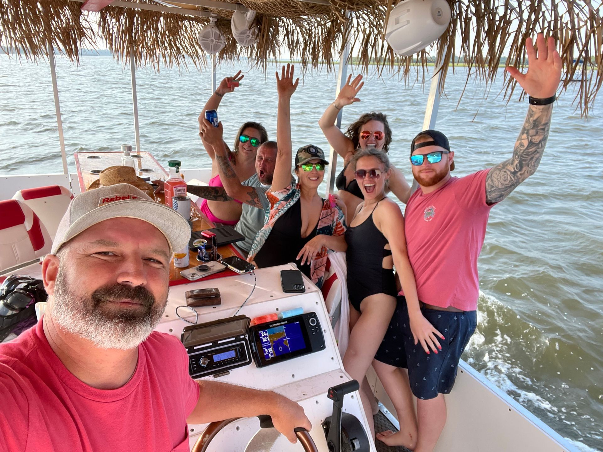 A group of people are standing on a boat in the water.