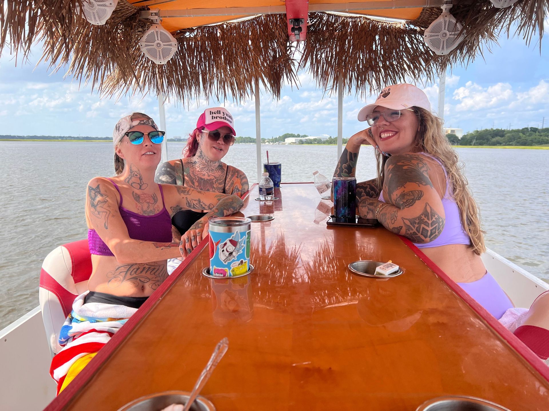 Three women are sitting at a table on a boat.