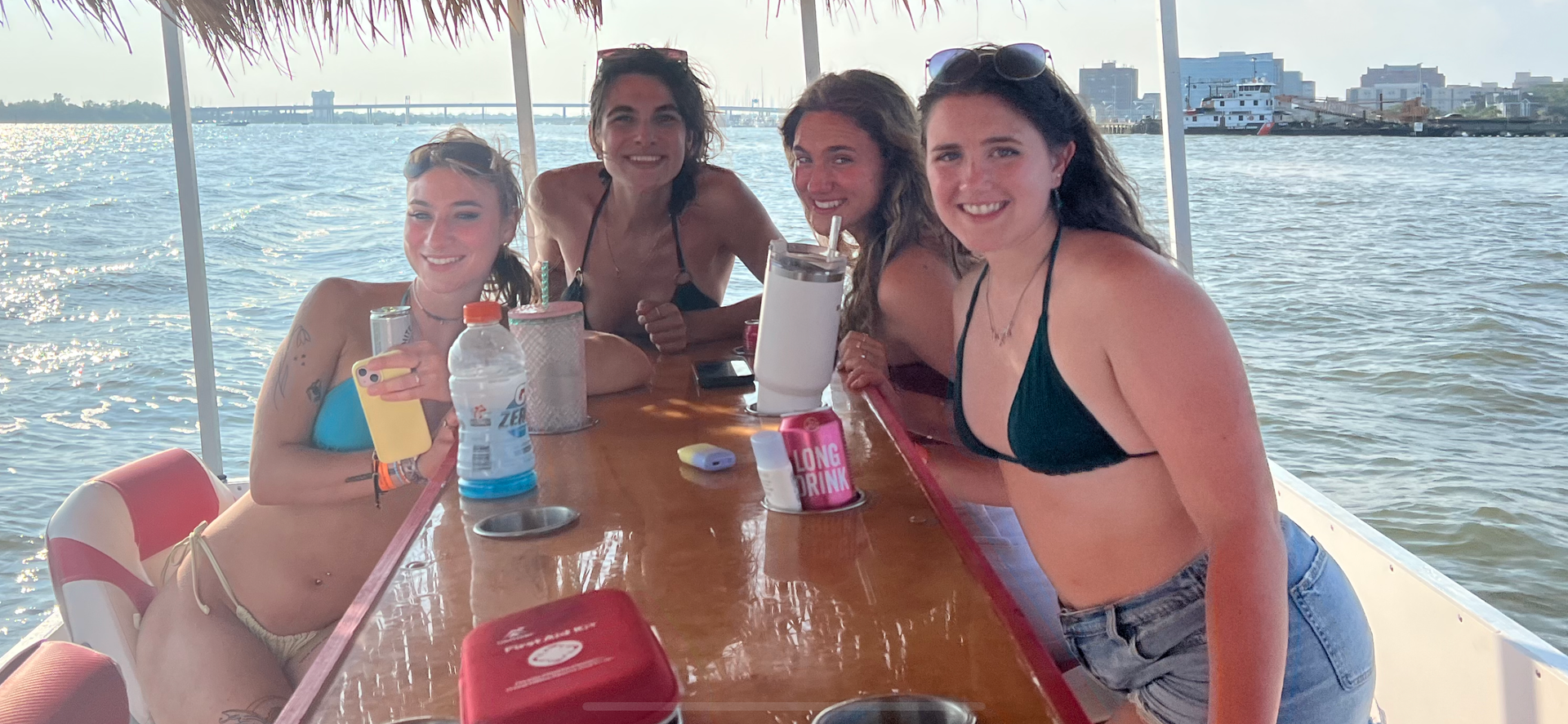 A group of women are sitting at a table on a boat.