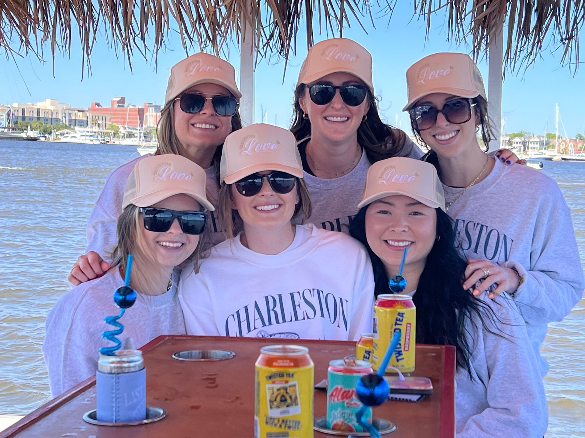 A group of women are posing for a picture while sitting at a table.