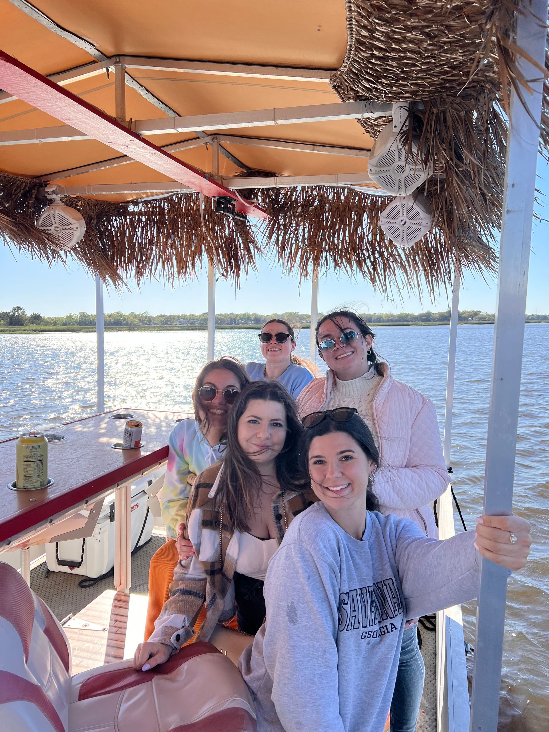 A group of women are sitting on a boat in the water.