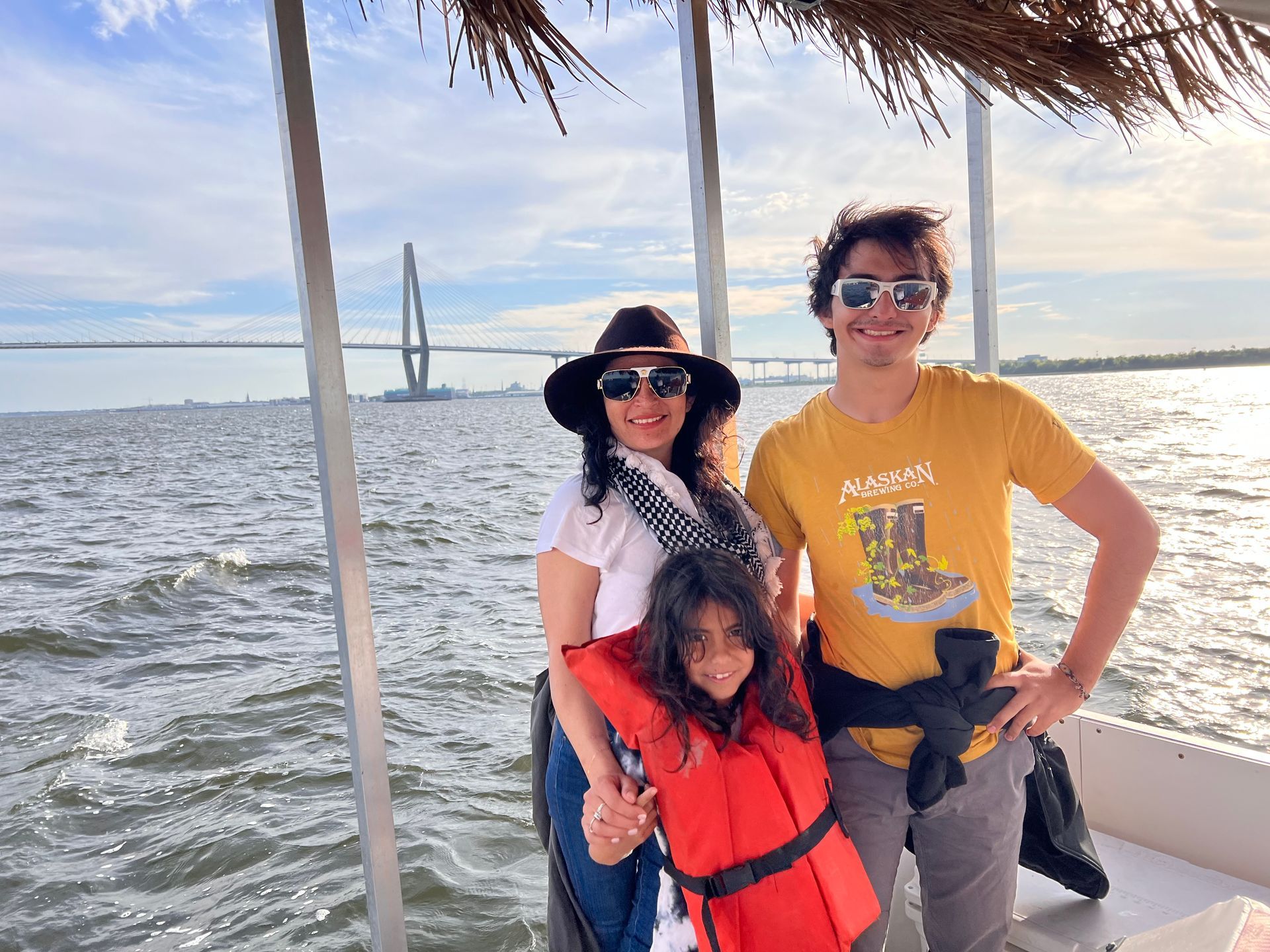 A family is standing on a boat in the water.