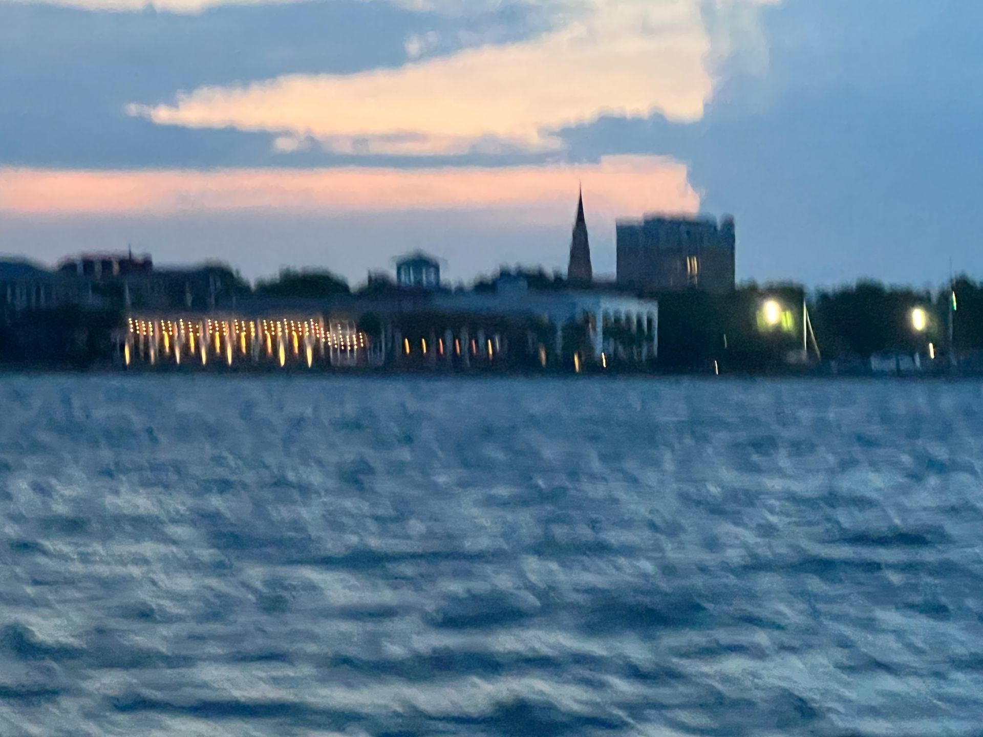 A city skyline is visible over a body of water at sunset.