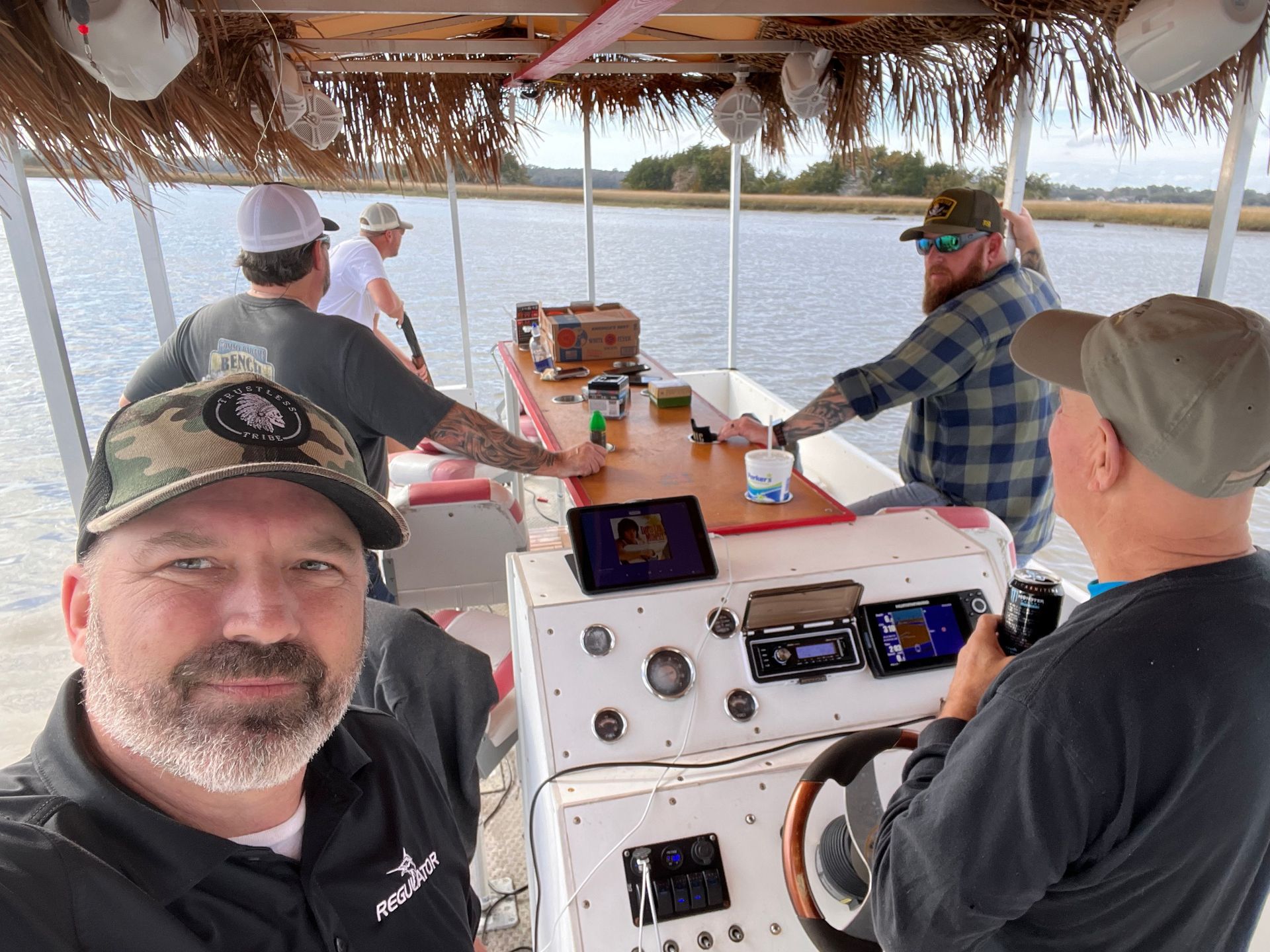 A group of men are sitting on a boat in the water.