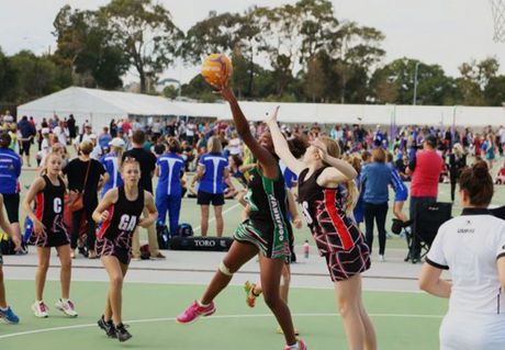 A group of girls are playing a game of netball