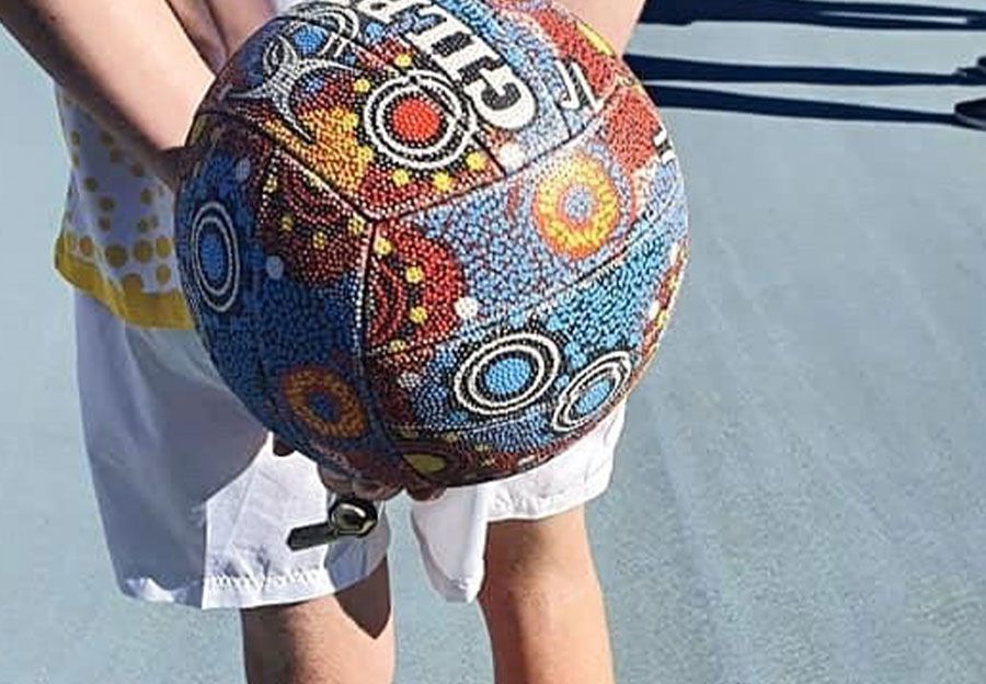 A person is holding a colorful basketball in their hands.