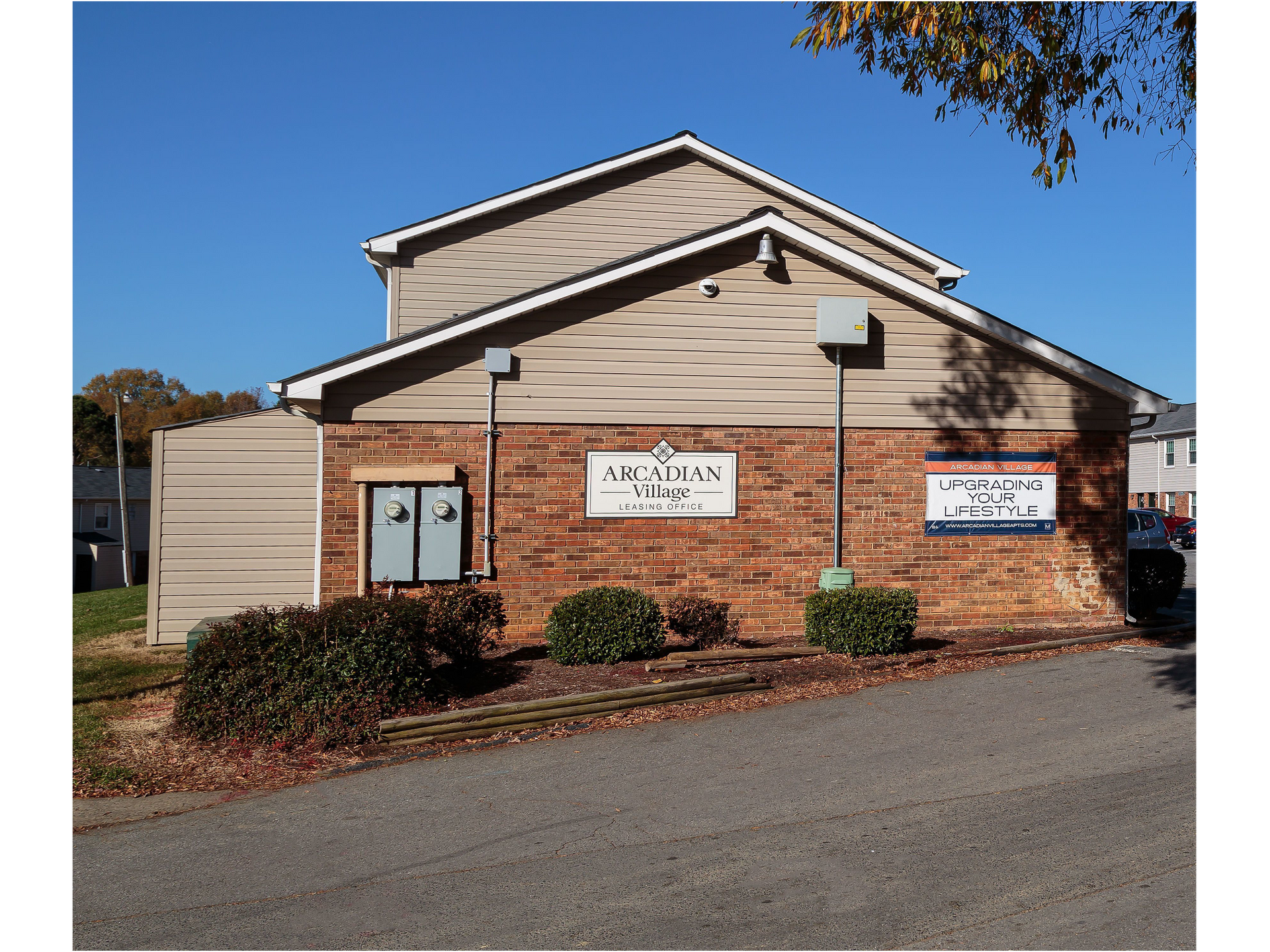 Exterior view of Arcadian Village leasing office with brick façade and signage.