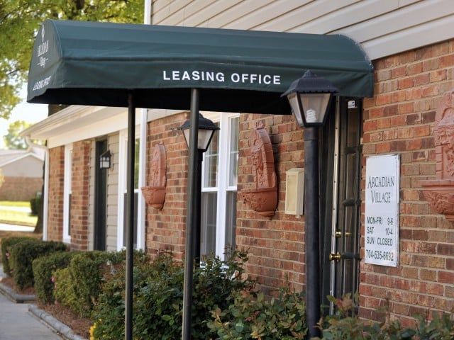 Leasing office entrance with a dark green canopy on a brick building.