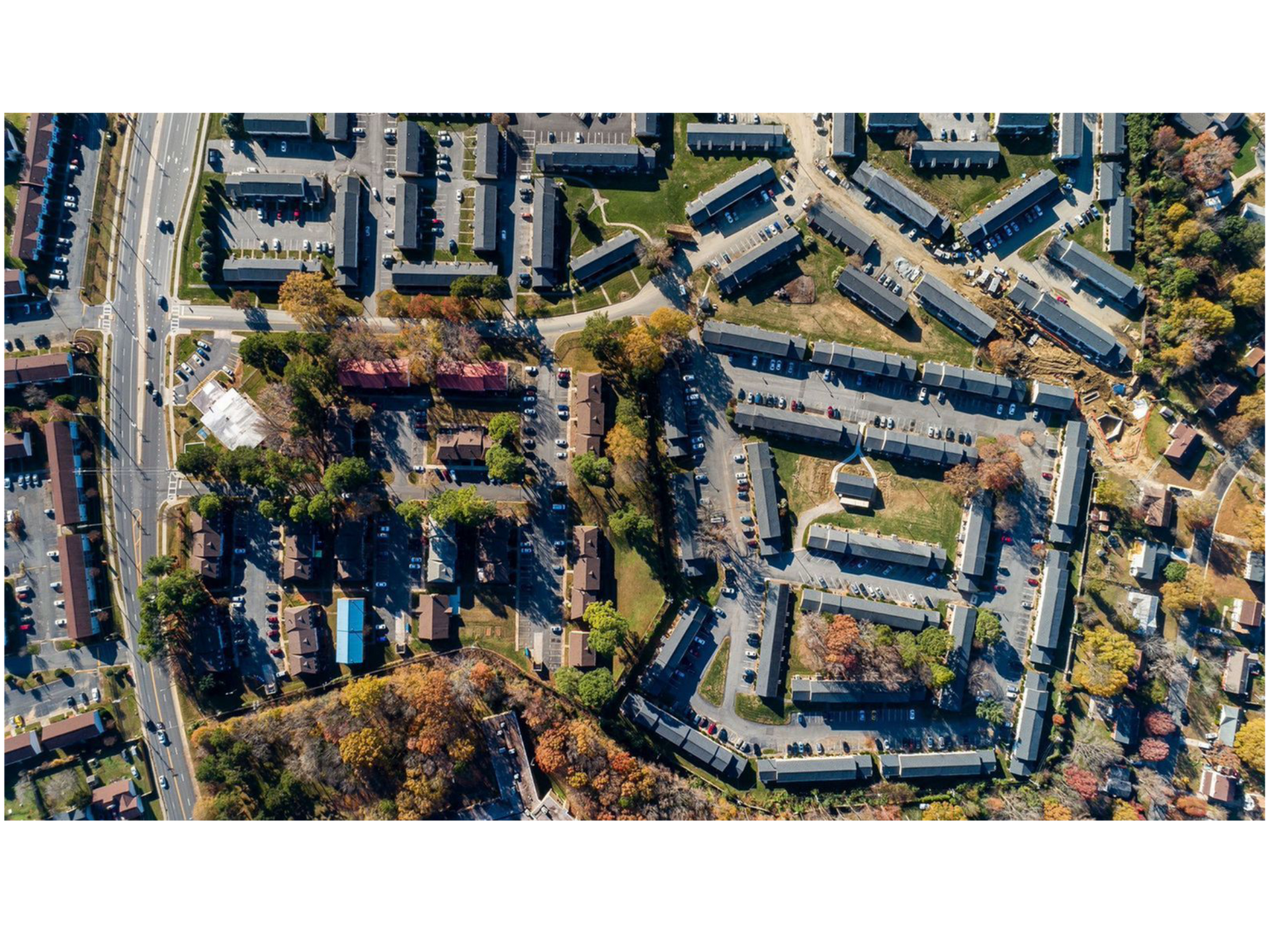 Aerial view of a large apartment community with multiple buildings and parking.