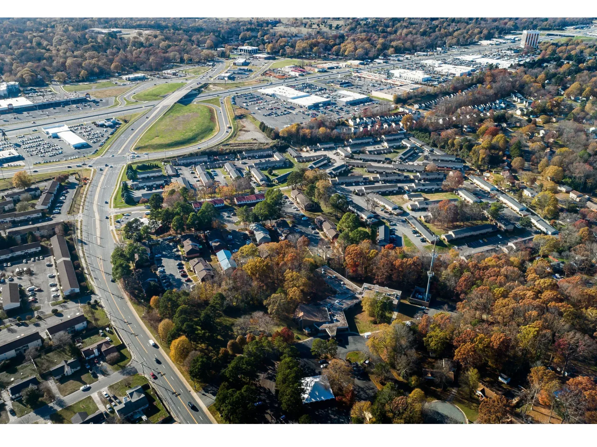 Aerial view of a suburban apartment community with roads and trees.