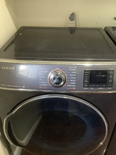A samsung washer and dryer is sitting in a laundry room.