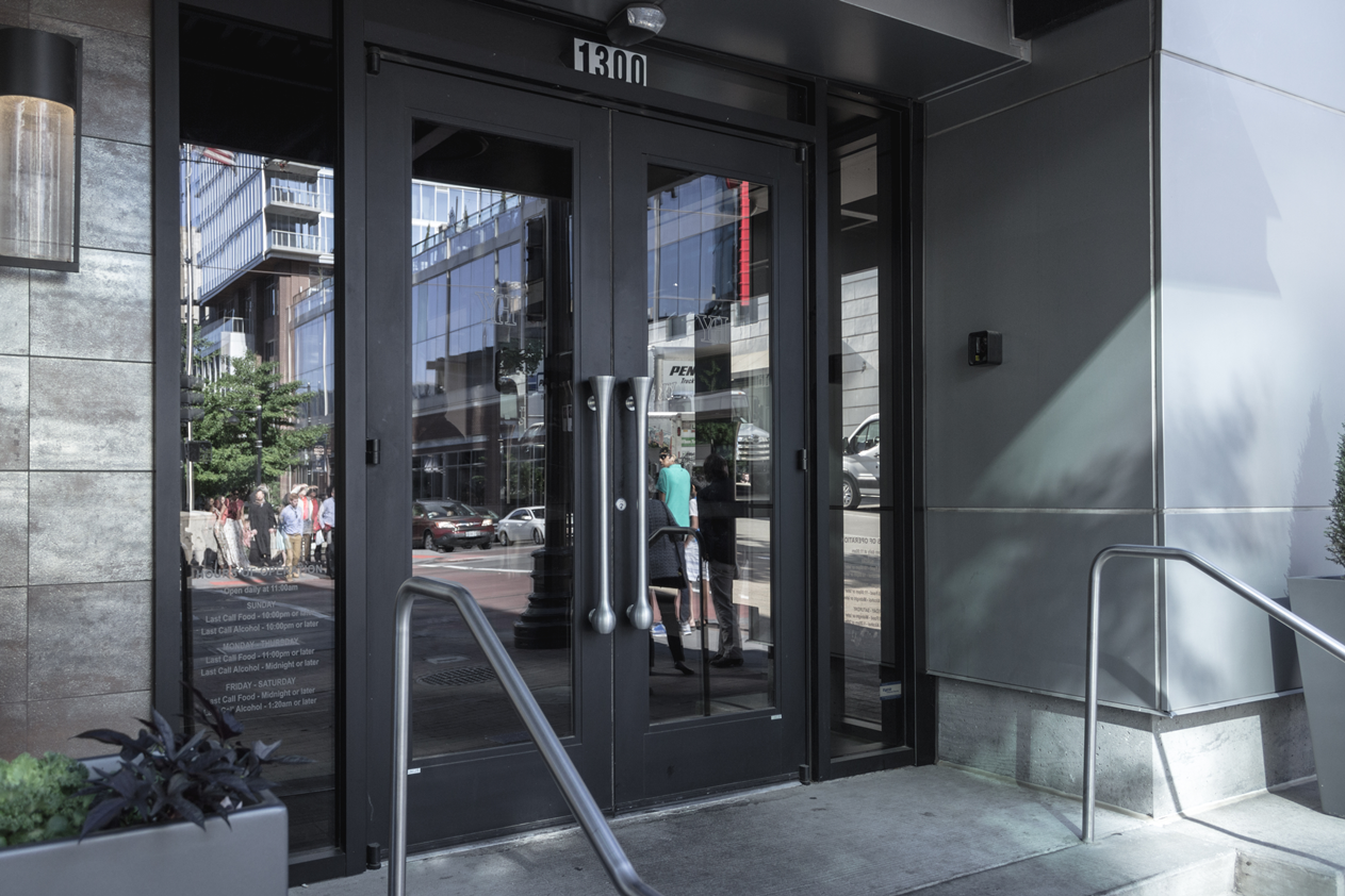 A building with a glass door and stairs leading to it.