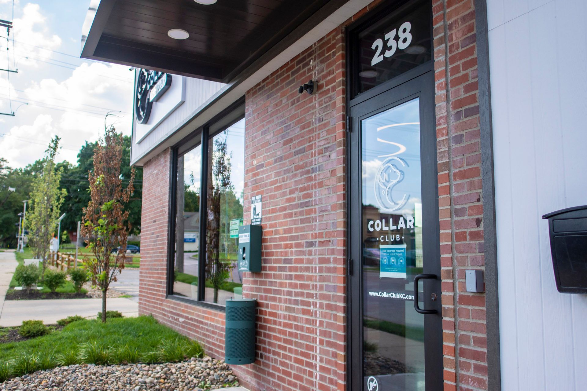 A brick building with a black door and a mailbox in front of it.