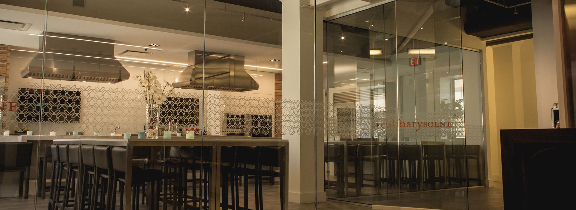 A restaurant with a lot of tables and chairs and a glass wall.