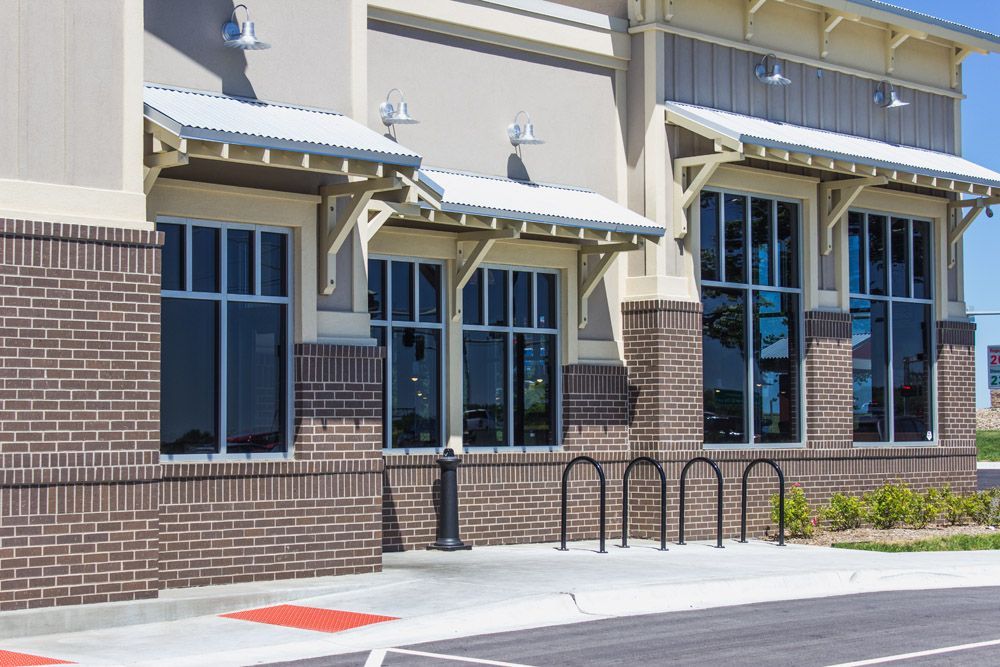 A large brick building with a lot of windows and a parking lot in front of it.