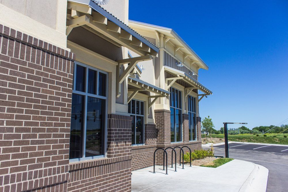 A brick building with a lot of windows and a parking lot in front of it.