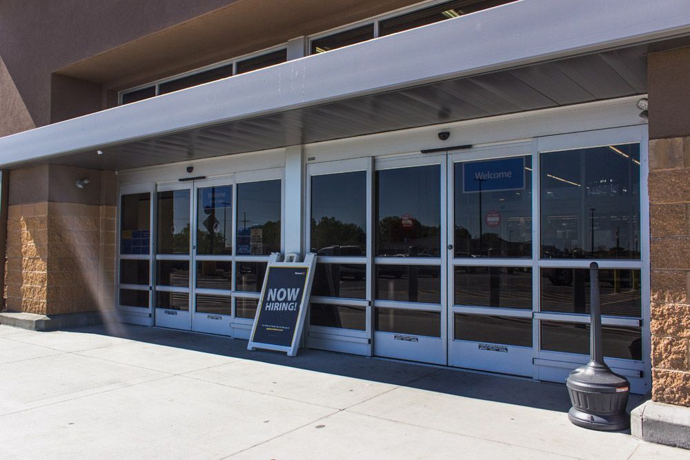 A store front with a sign that says now hiring