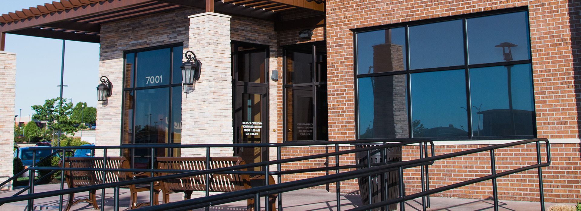 A brick building with a handicap ramp leading to the front door.