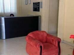 Una silla roja está en una habitación al lado de un mostrador.