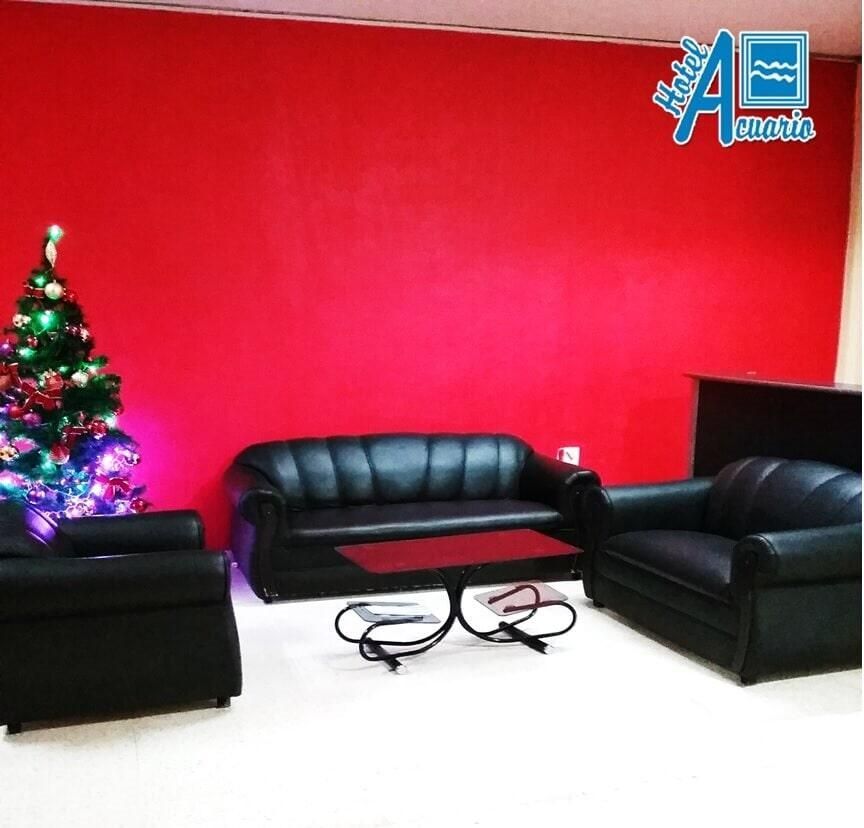 Una sala de estar con una pared roja y un árbol de Navidad.