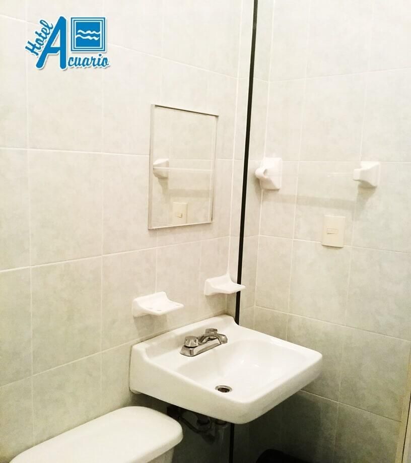 Un baño con inodoro, lavabo y espejo.