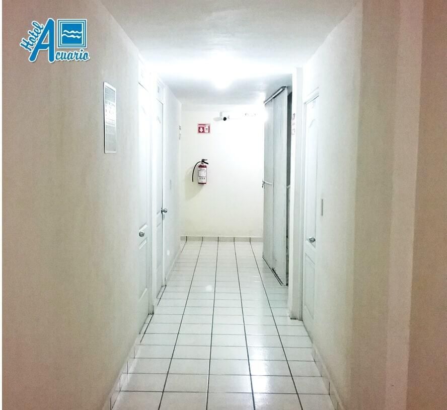 Un pasillo con un extintor de incendios en la pared.