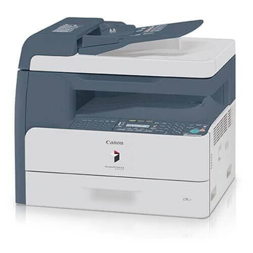 Una impresora Canon está sentada sobre una superficie blanca.