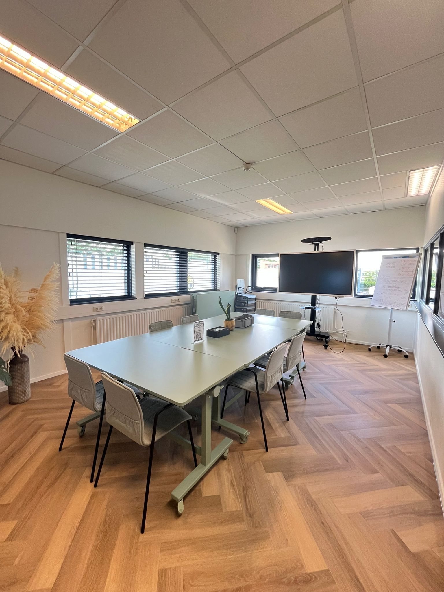 Een grote conferentieruimte met een lange tafel en stoelen.