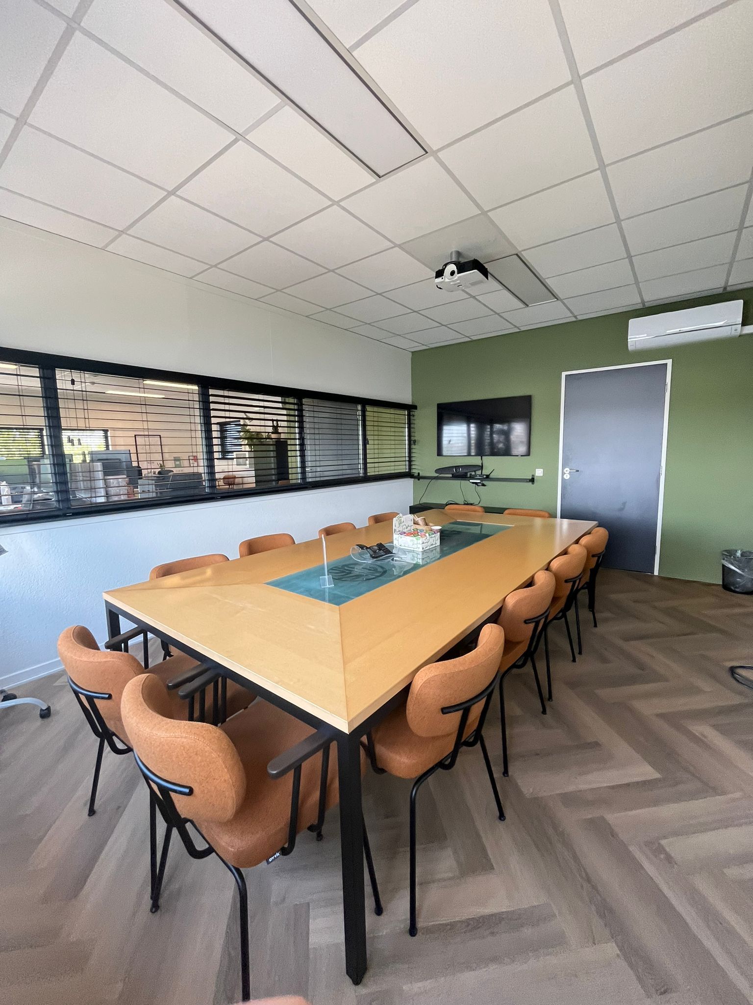 Een vergaderruimte met een lange tafel en stoelen