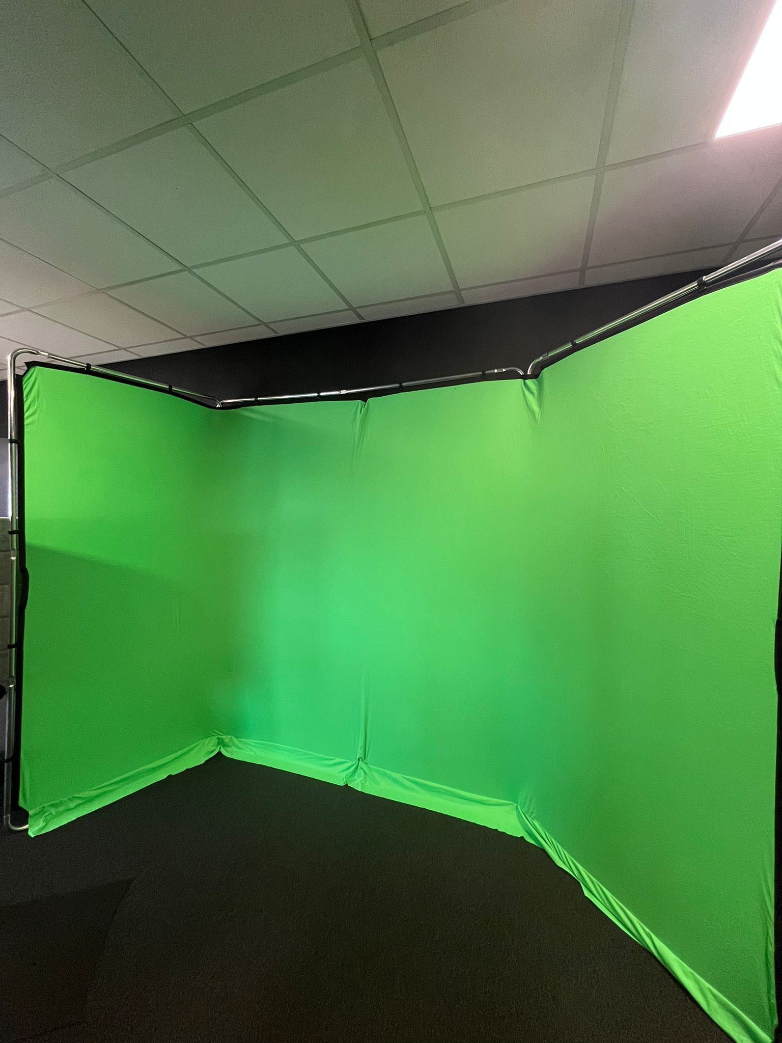 Er is een groen scherm in de hoek van de kamer.