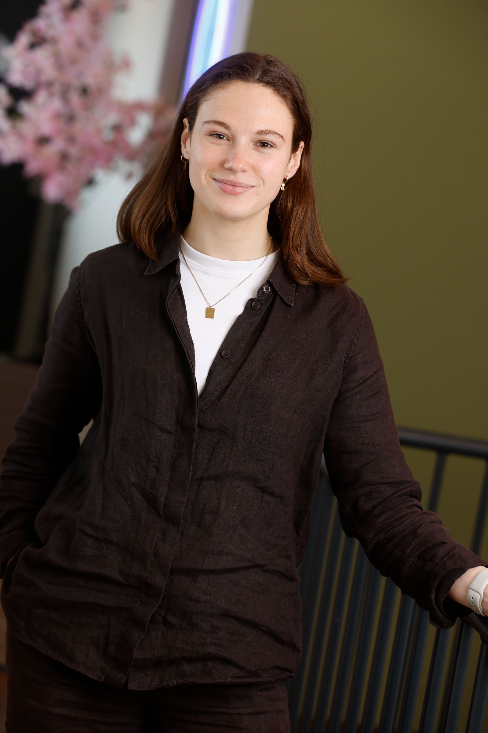 Een vrouw in een blauw-wit gestreept shirt staat met haar handen in haar zij.
