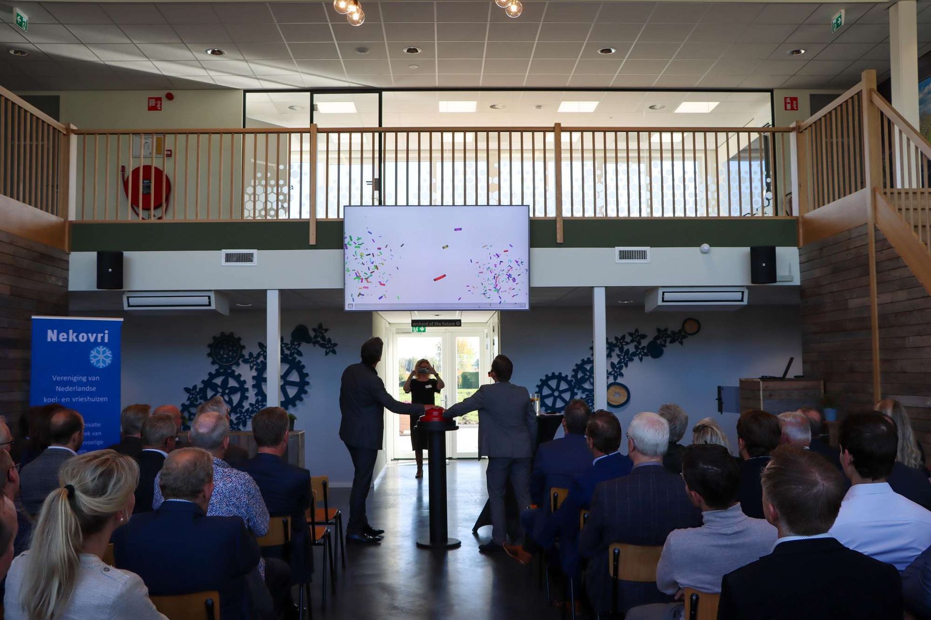 Een groep mensen zit in een kamer met een bord waarop staat kickstart