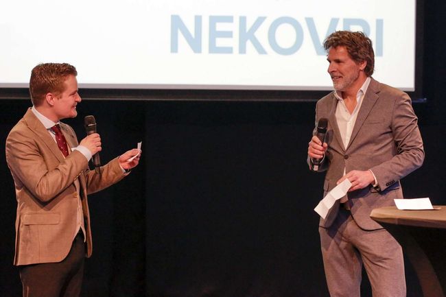 Twee mannen staan voor een scherm waarop nekovri staat
